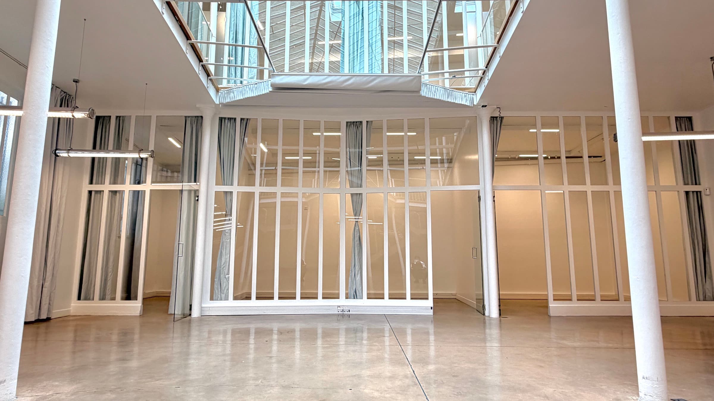 Vue frontale du plateau avec colonnes en fonte et cloisons verrières sous la mezzanine