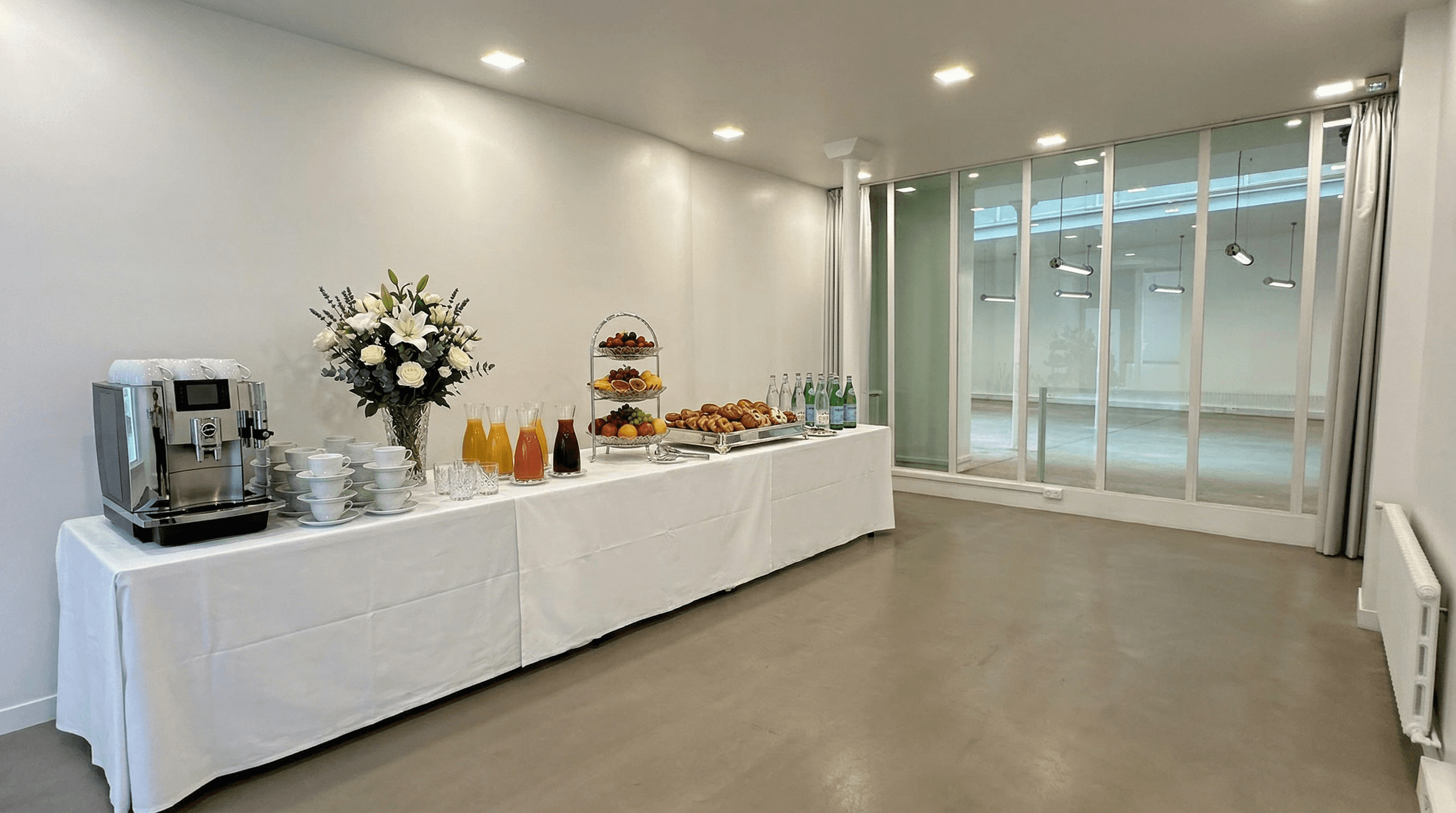 Buffet traiteur avec fleurs et viennoiseries dans la salle latérale
